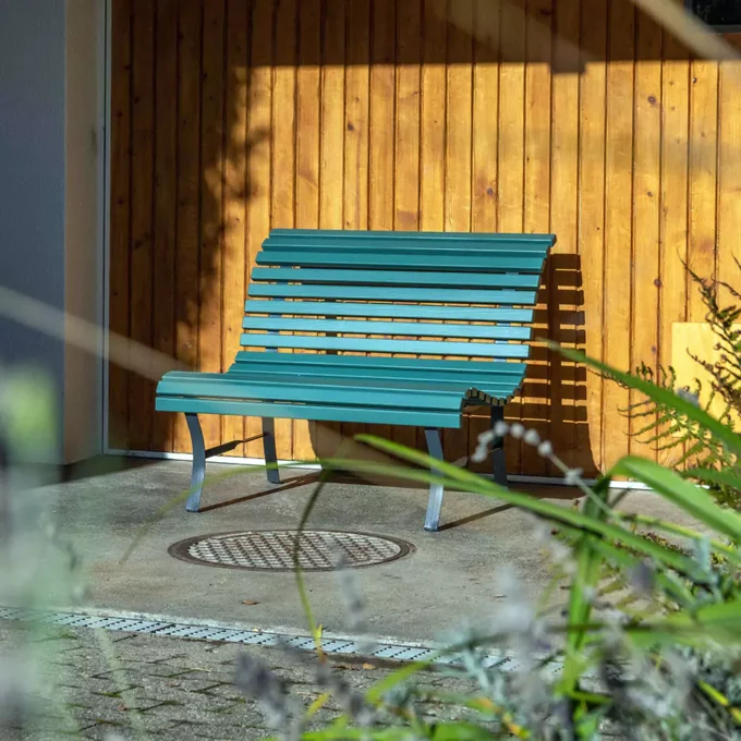 Klassische Gartenbank mit Holzbelattung aus Emmentaler Weisstannen Starkholz und Petrolgrün-Lasur in der Länge von 1 Meter. Die Standfüsse aus Gusseisen in Antrazit.